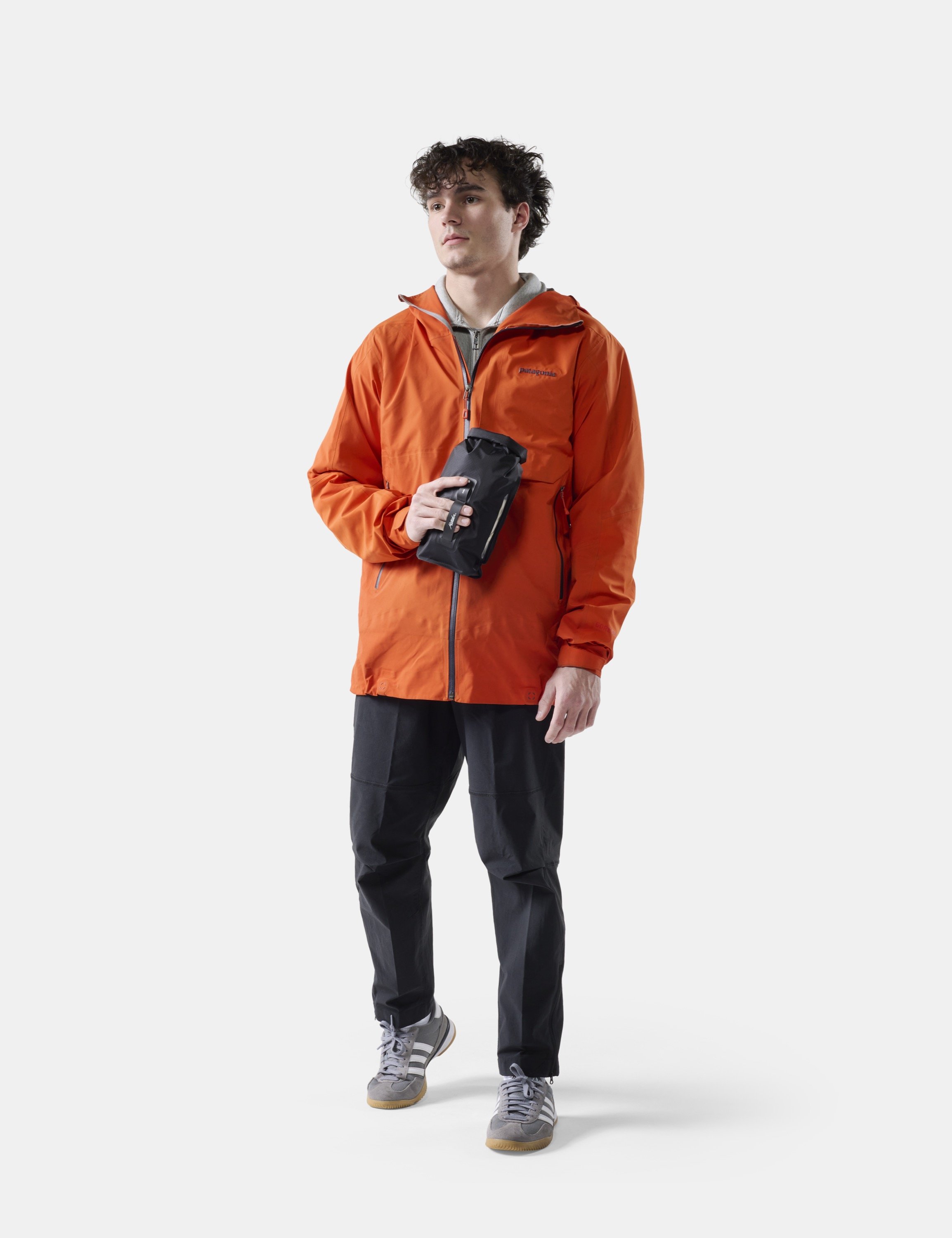 orange jacket, windbreaker, soft shell, black pants, crossbody pouch