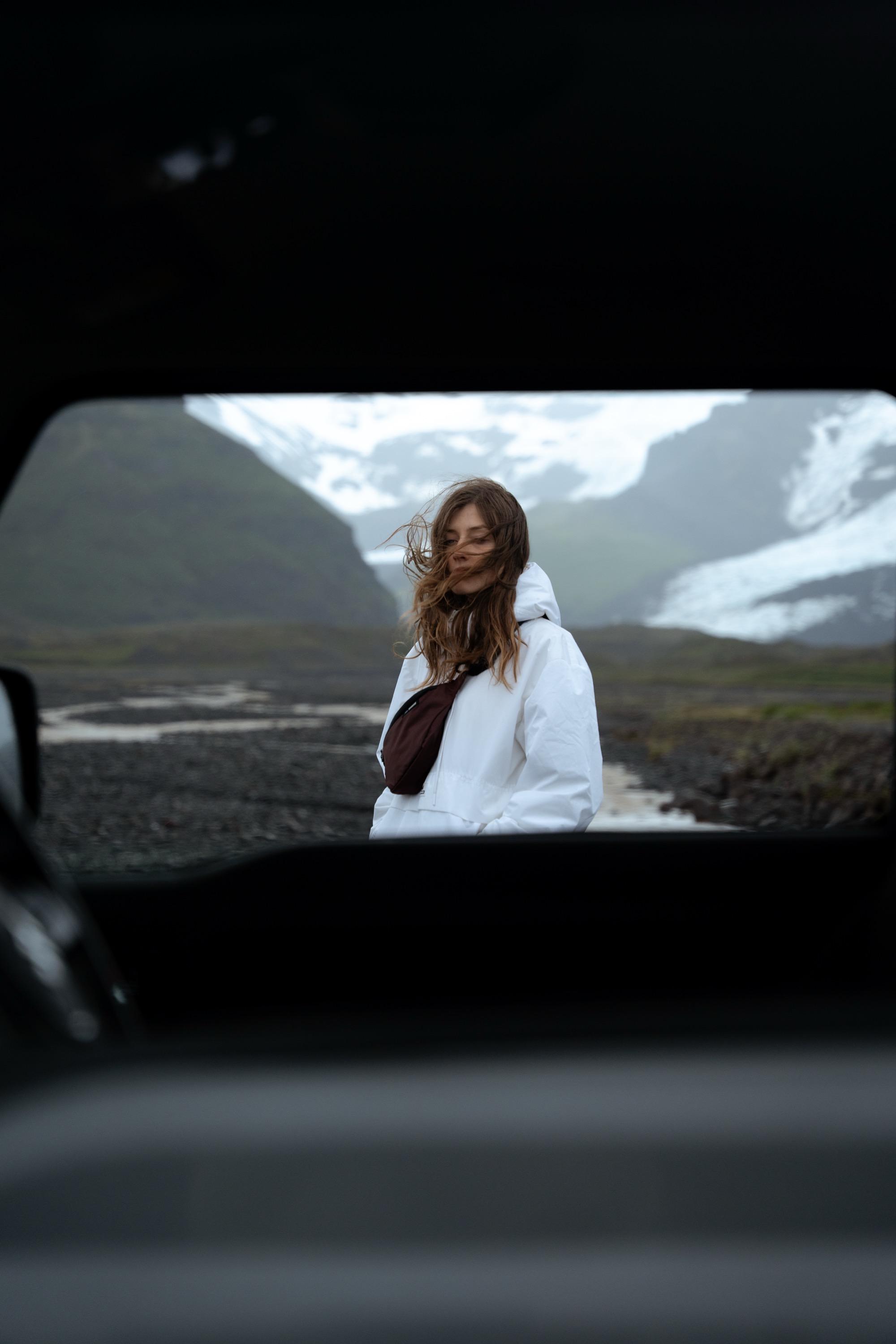 white jacket, hooded jacket, windbreaker, brown chest bag, mountain landscape