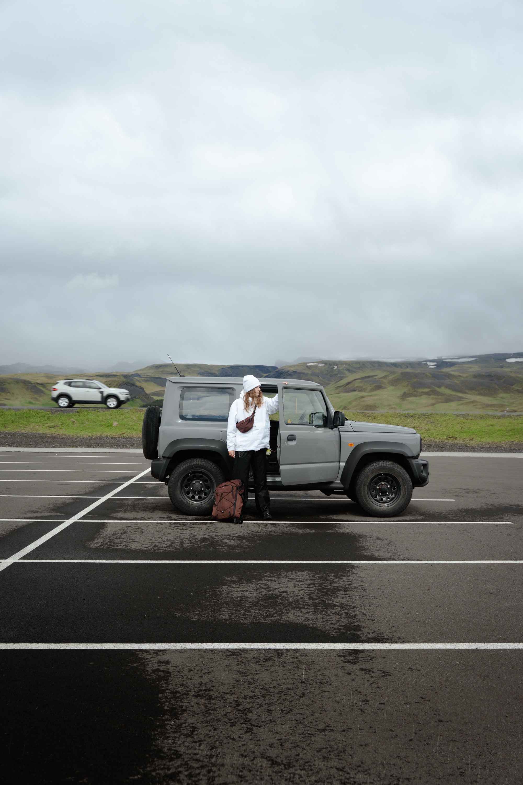 SUV, Offroad, grau, Parkplatz, Person mit Rucksack